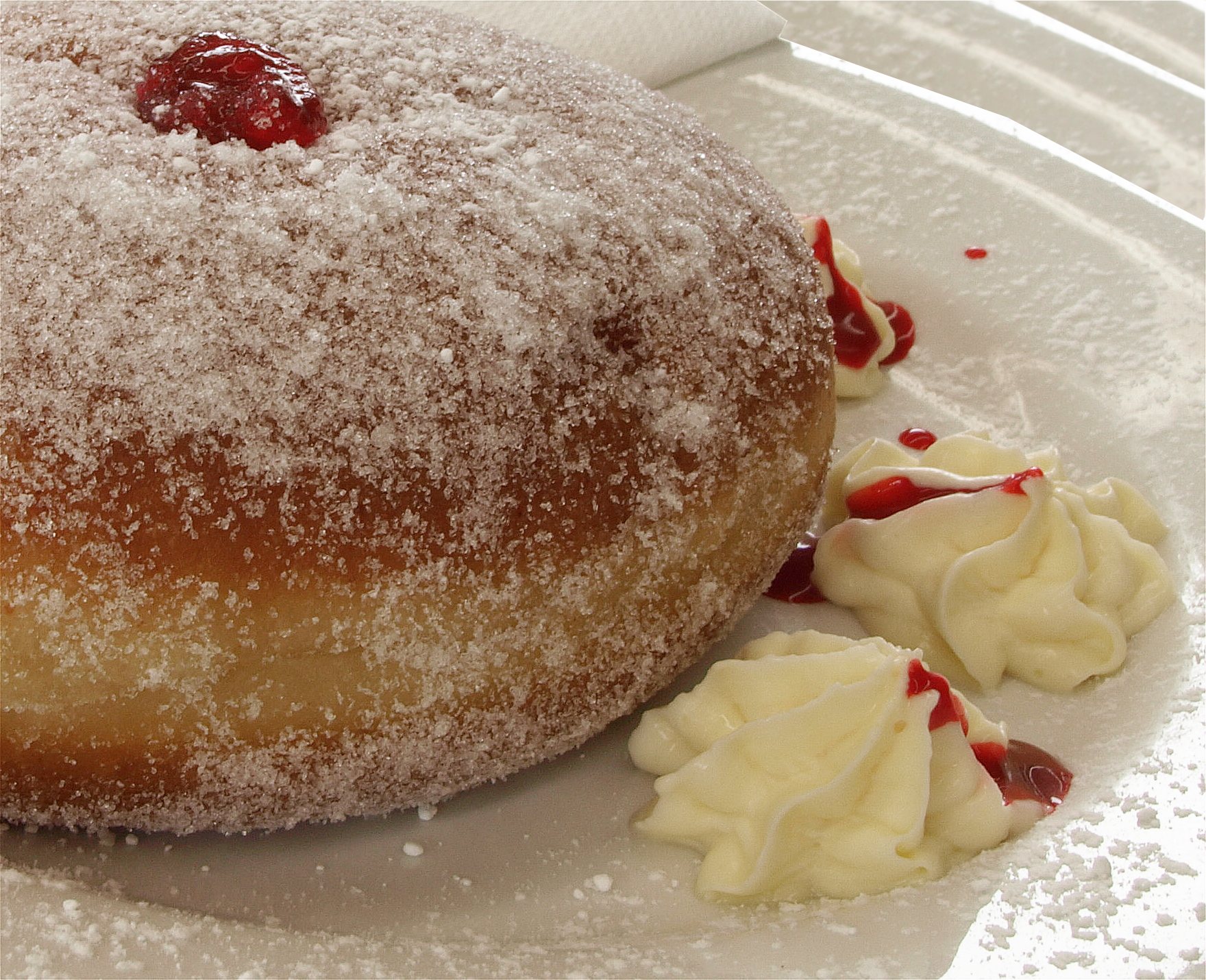 the dessert on the plate has many small pieces of cream and strawberry compote