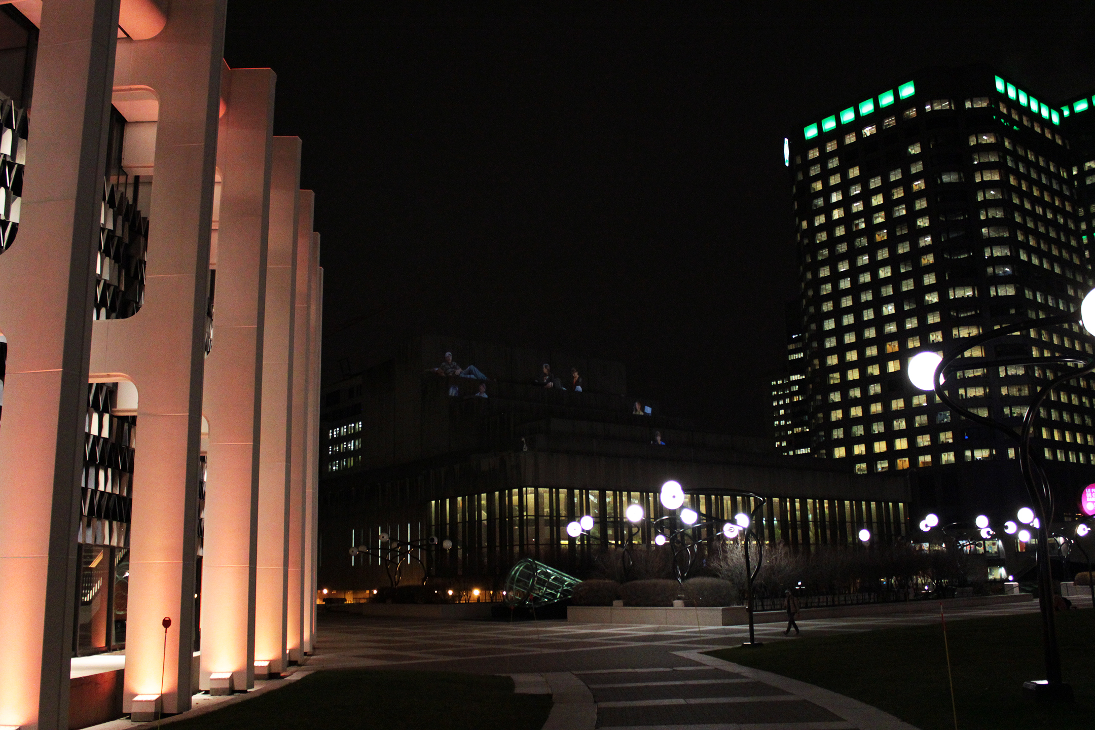 buildings at night near a street with light up displays