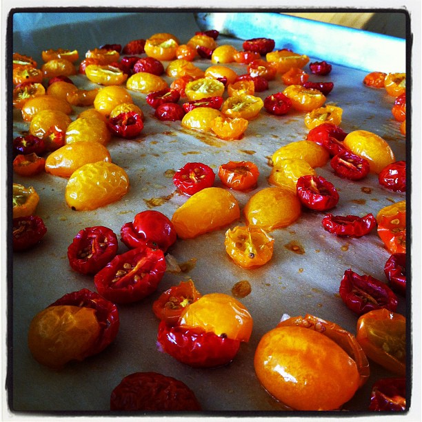 oranges and peppers on a baking sheet in an oven