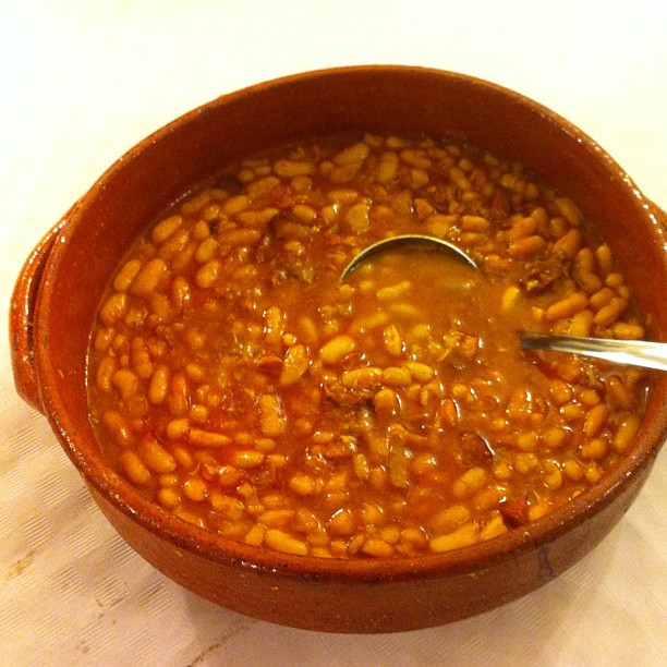 a spoon in a bowl filled with beans
