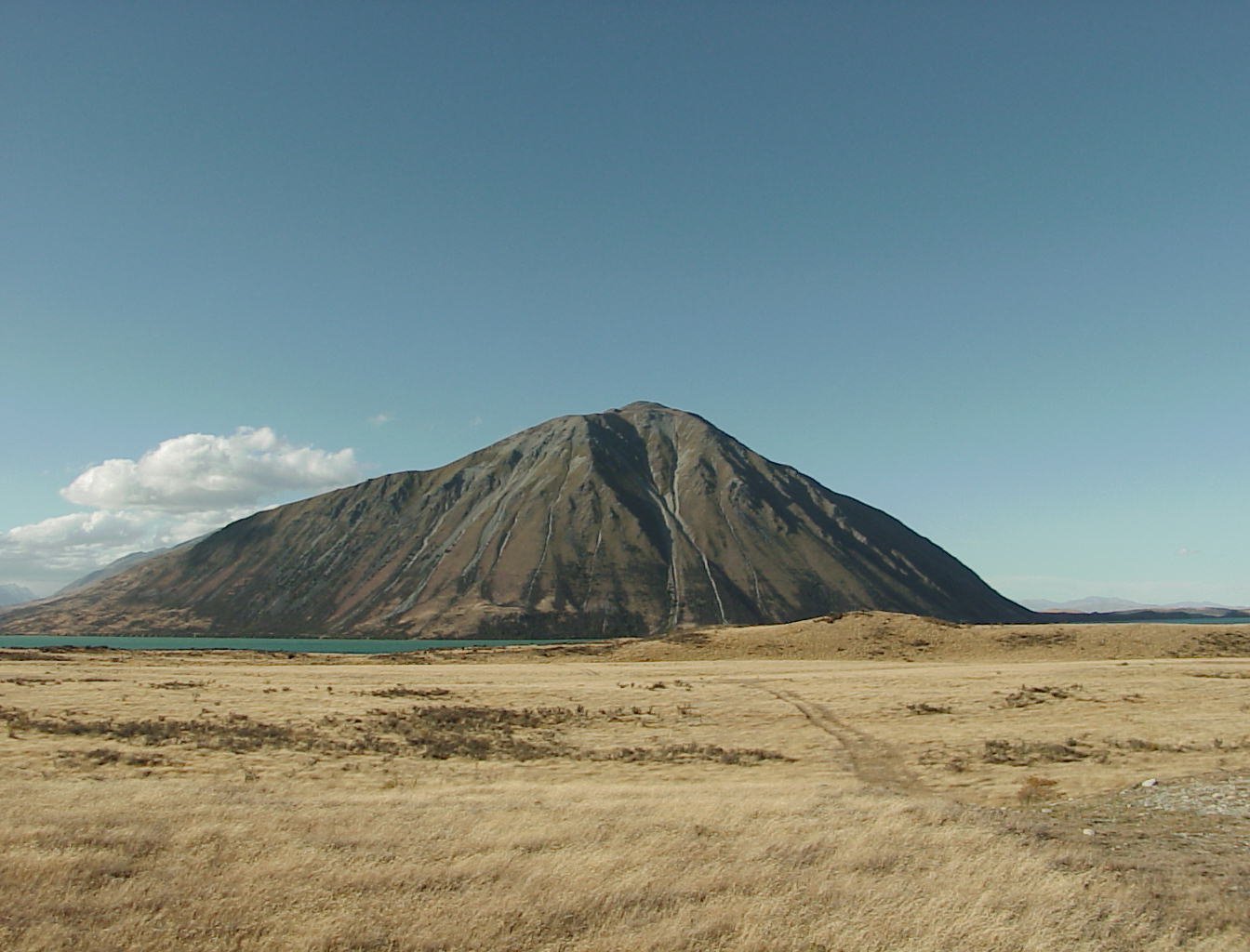 a mountain in the distance with a body of water behind it