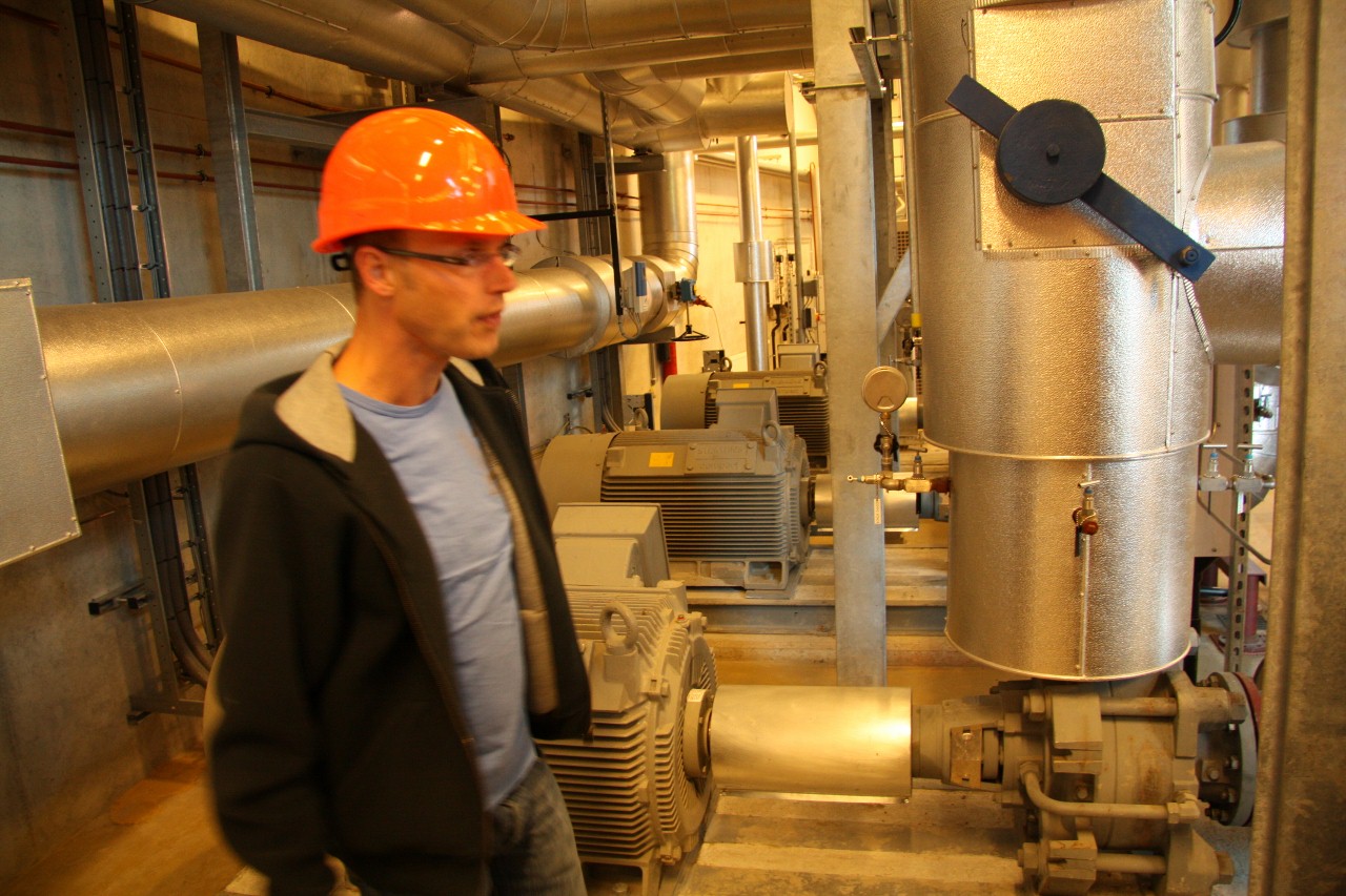 man in hardhat in large factory machinery