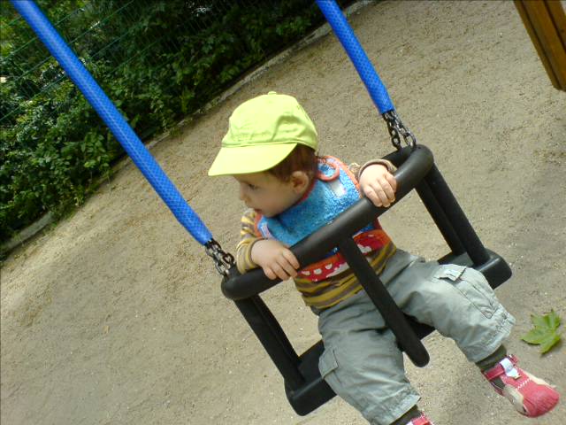 a young child on a swing at the park