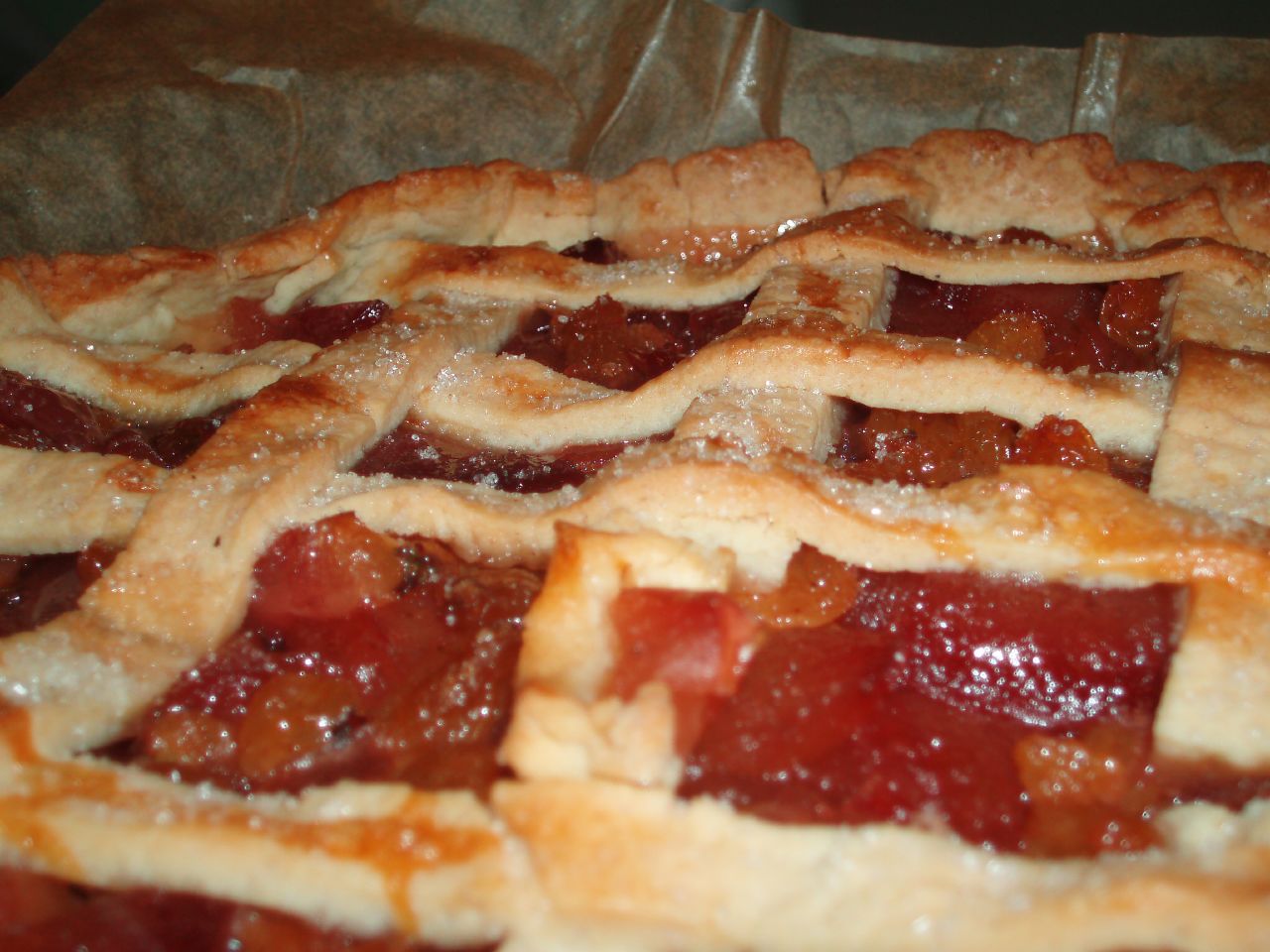 the baked pastry in the baking tray has strawberry jam