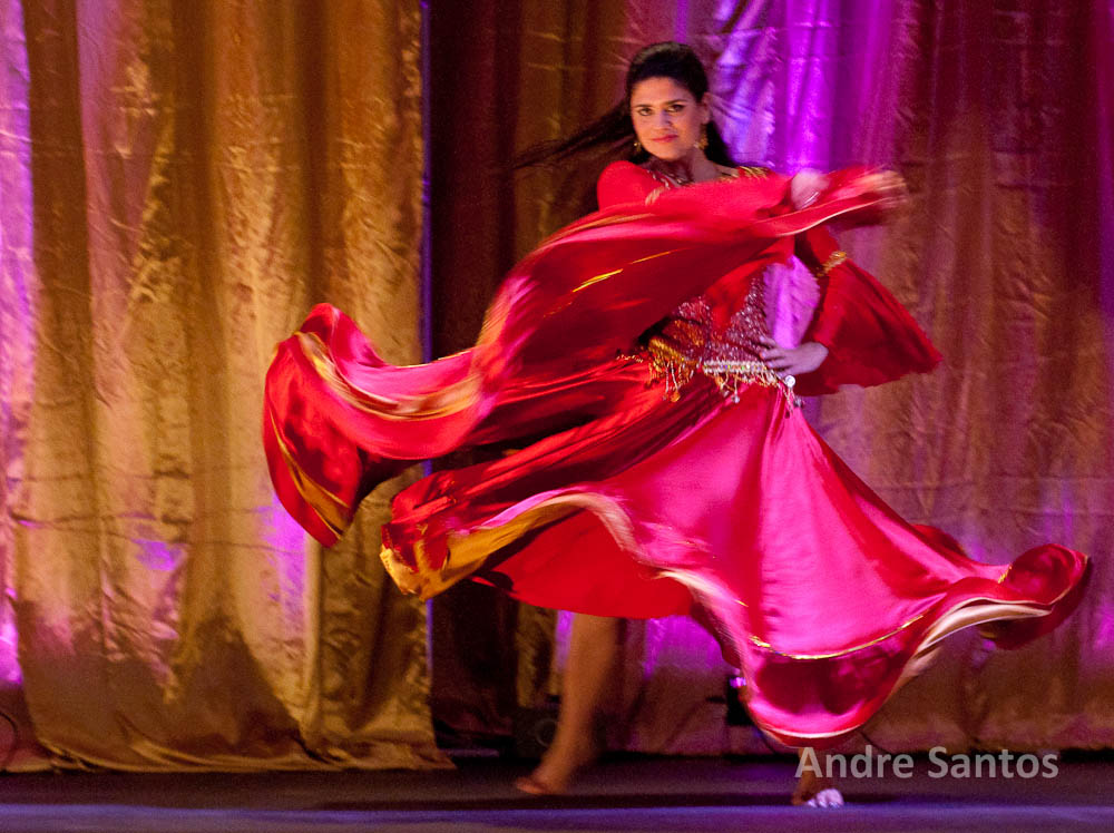 a beautiful woman dressed in an oriental dress is doing a dance