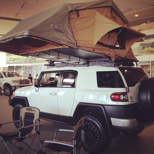 an suv with a tent attached in a parking garage