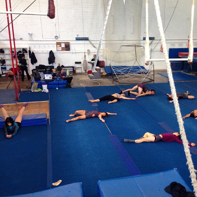 several women lying in the middle of a gym area