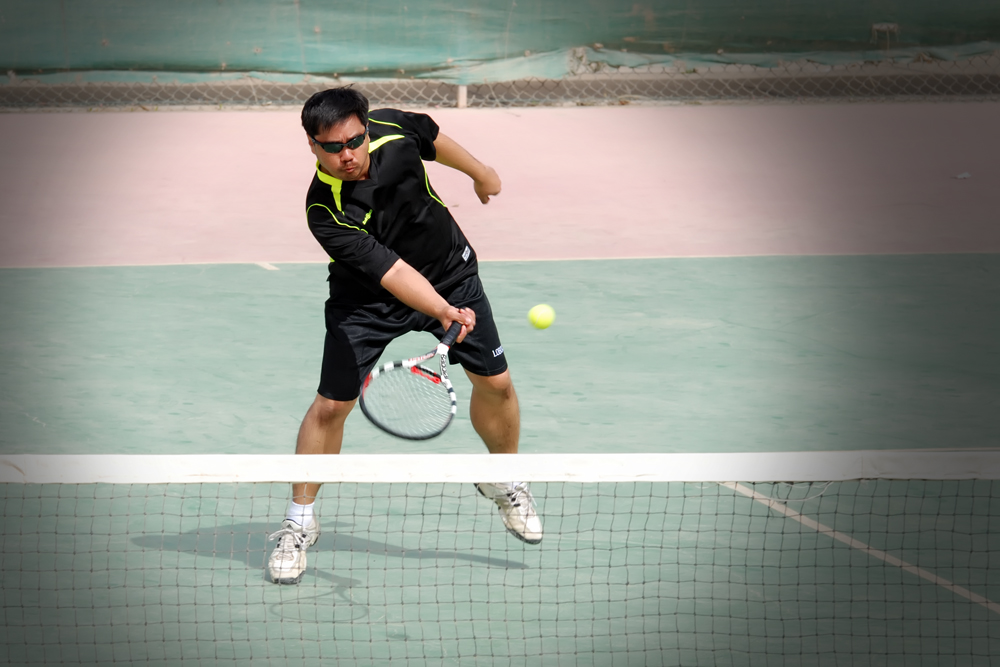 a tennis player swinging his racket to hit the ball