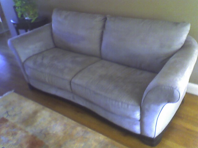 the grey couch is in front of a window