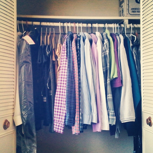 a closet containing a variety of shirts hanging from hooks