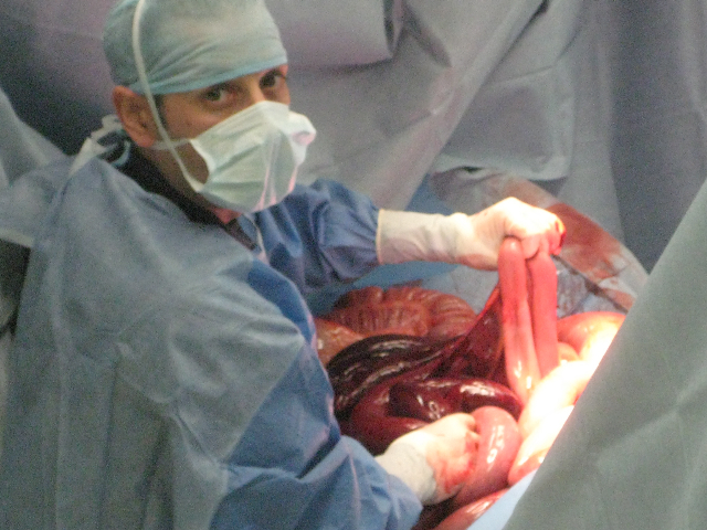 a man in sterile clothing holds a piece of food in his hands