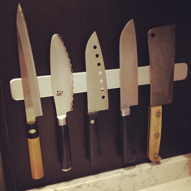 knives mounted on a wall behind a kitchen door