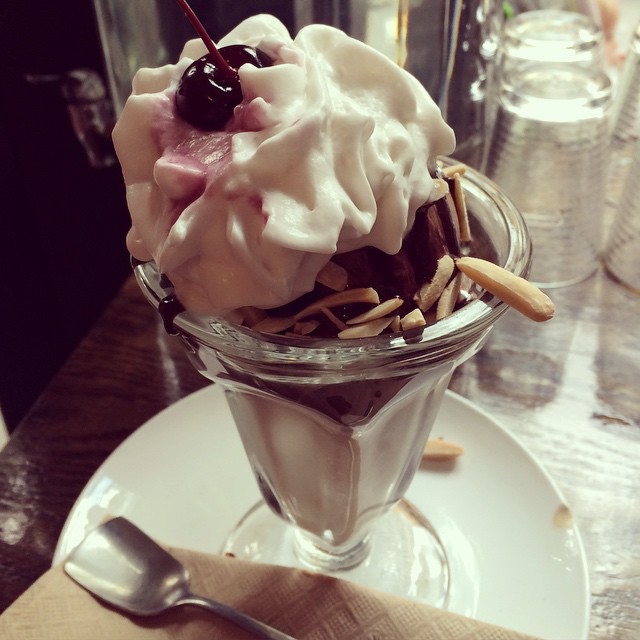 an ice cream sundae on a plate with a spoon