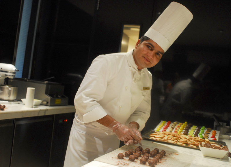 a man in chef's hat is in a kitchen preparing food