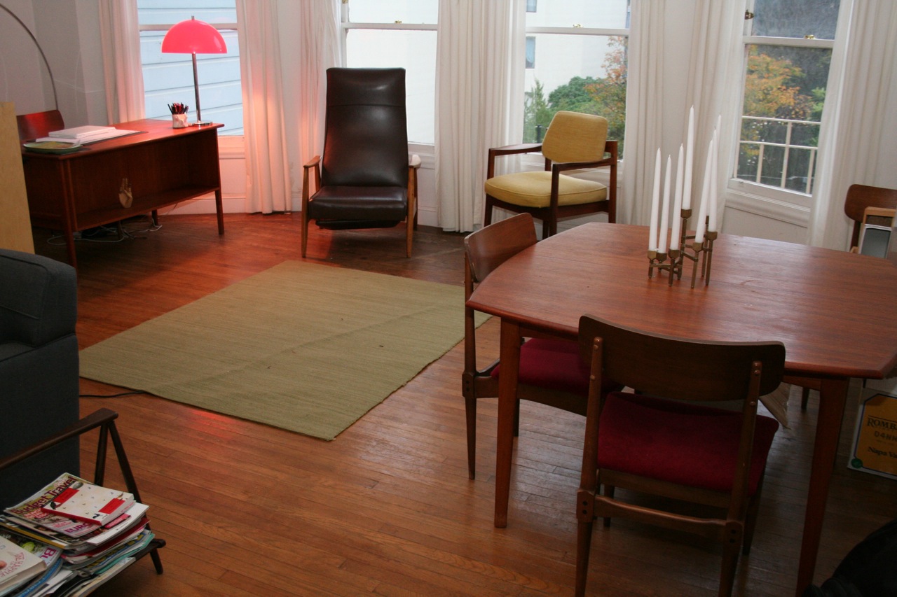 a room with chairs, a couch, table and lamps