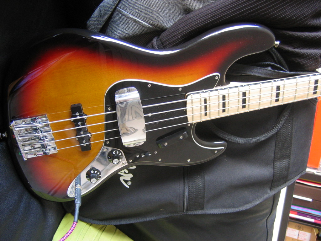 an electric bass guitar is laying on its side in a case