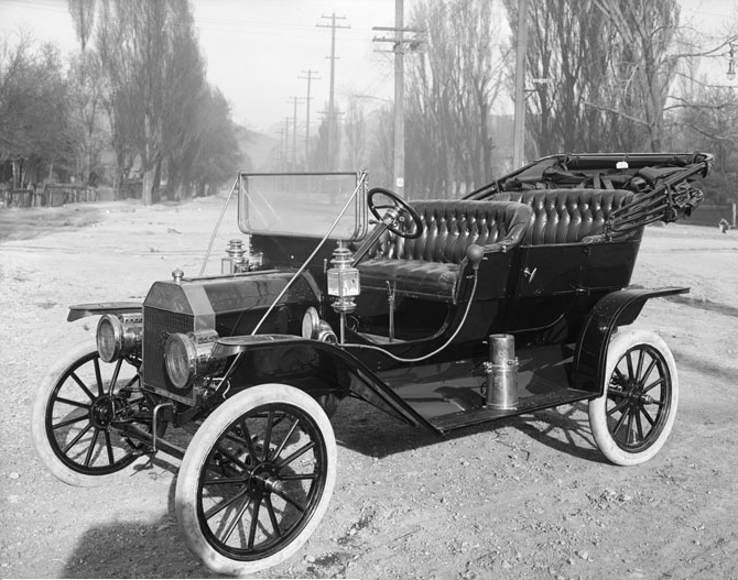 the antique car has been sitting on the dirt