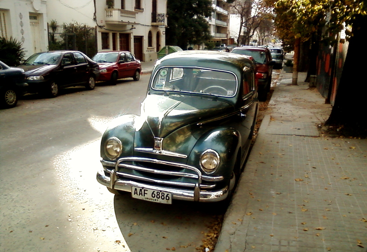 a green and white vintage car parked on the street