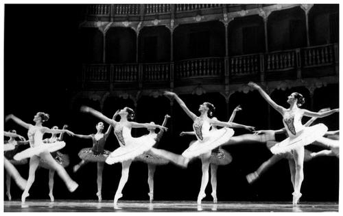 dancers in ballet attire on a stage performing
