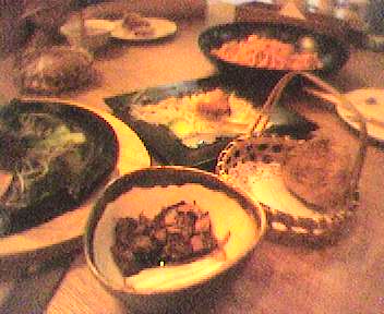 some plates filled with food and salad on top of a wooden table