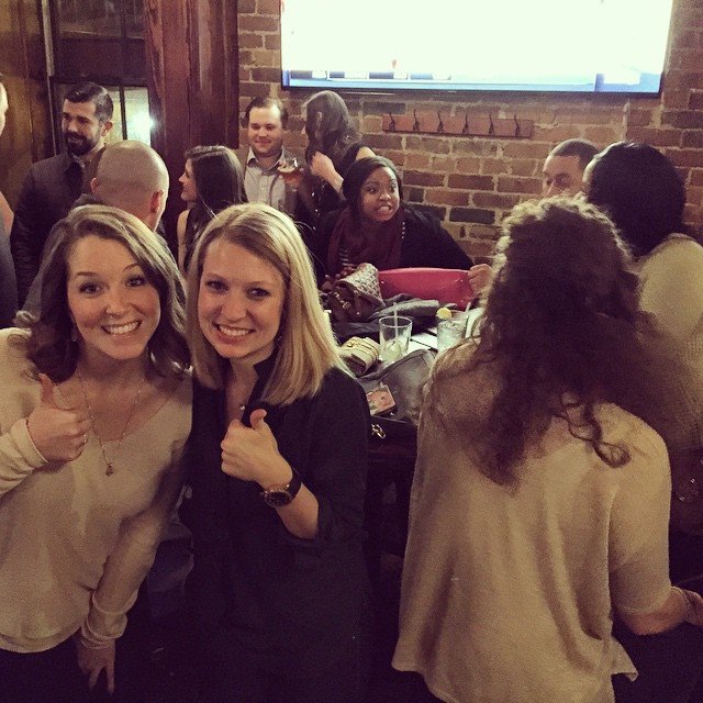two women are standing together and making thumbs up