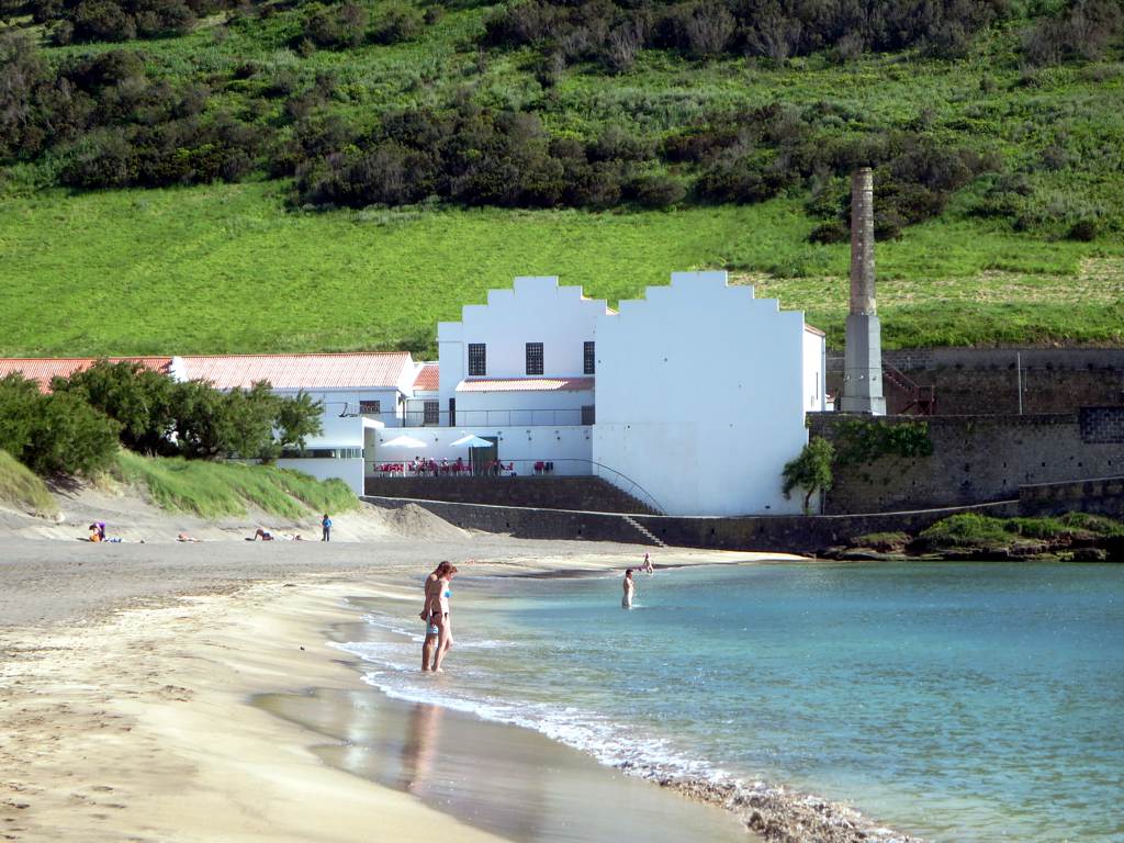 a small white building on the side of a beach