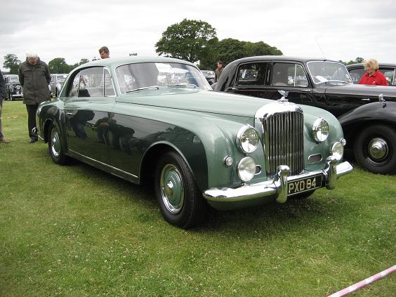 an old style green car at a show
