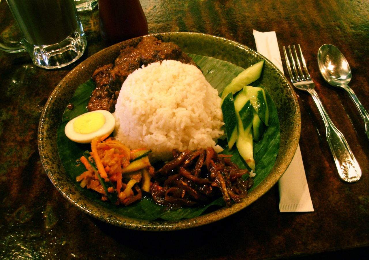 a brown plate topped with rice and meat