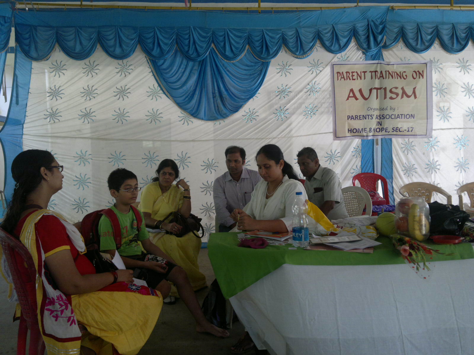 five people sitting around a table reading books