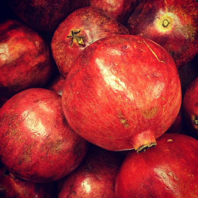 a pile of pomegranates sitting in a large display bowl