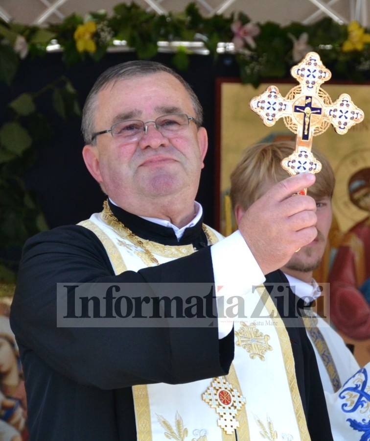 a priest holding a cross with other people nearby