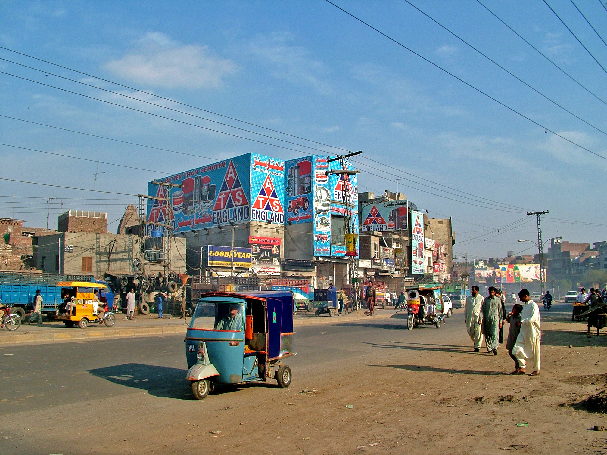 a city street with cars and people and billboards on the buildings