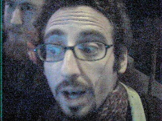 man with glasses, scarf and looking surprised at the camera