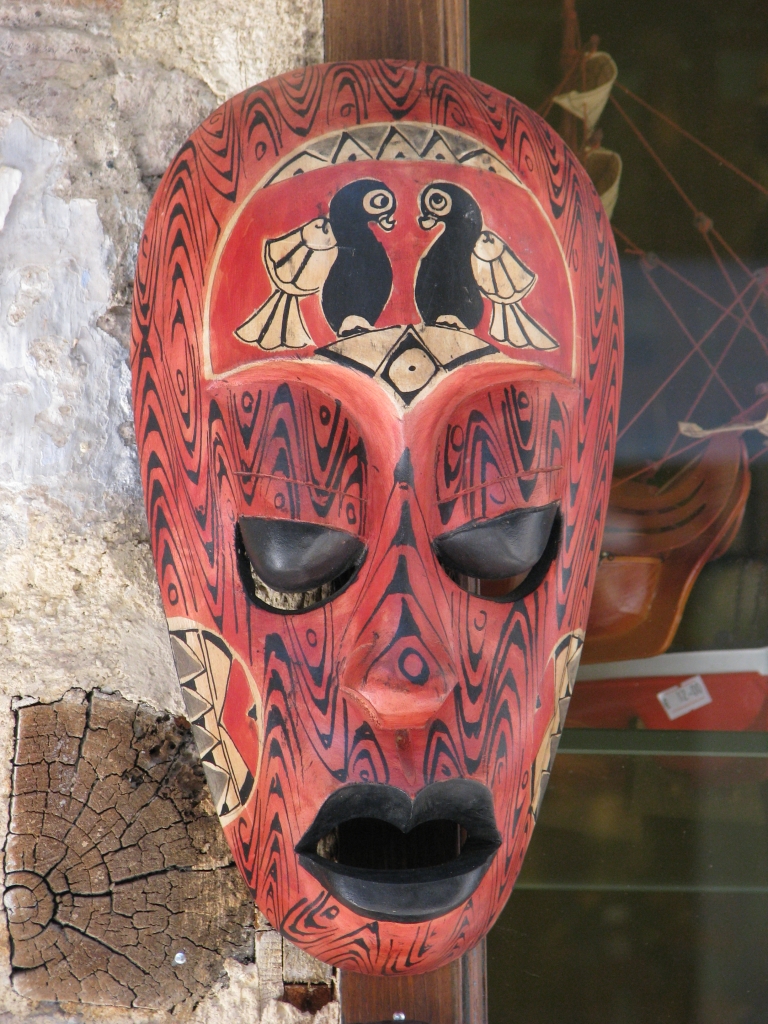 a mask in a shop window near some logs
