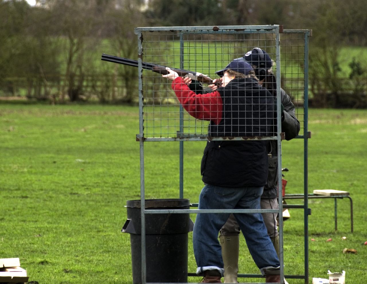 the people are aiming the objects in the cage