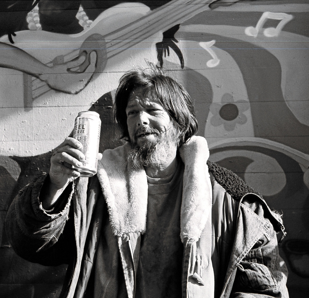 a man wearing a scarf with a beer in hand