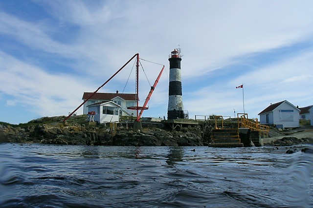 a lighthouse sitting on top of a island surrounded by water