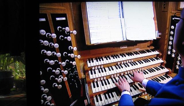 two men who are playing on a pipe organ