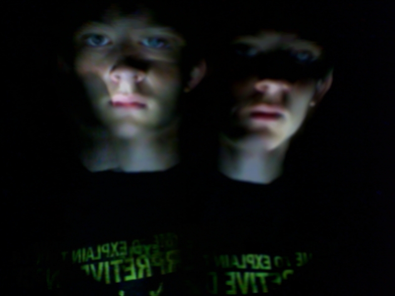 two young males are pographed in the dark