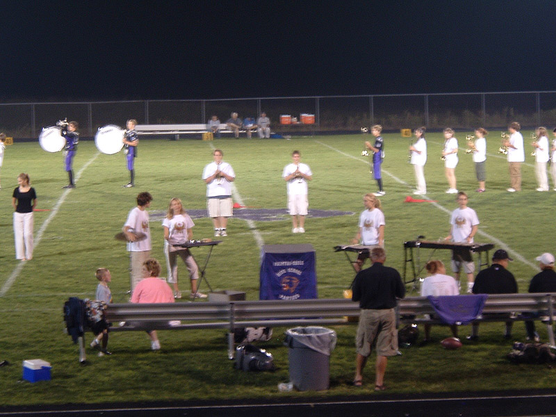 a group of people singing and playing on the field