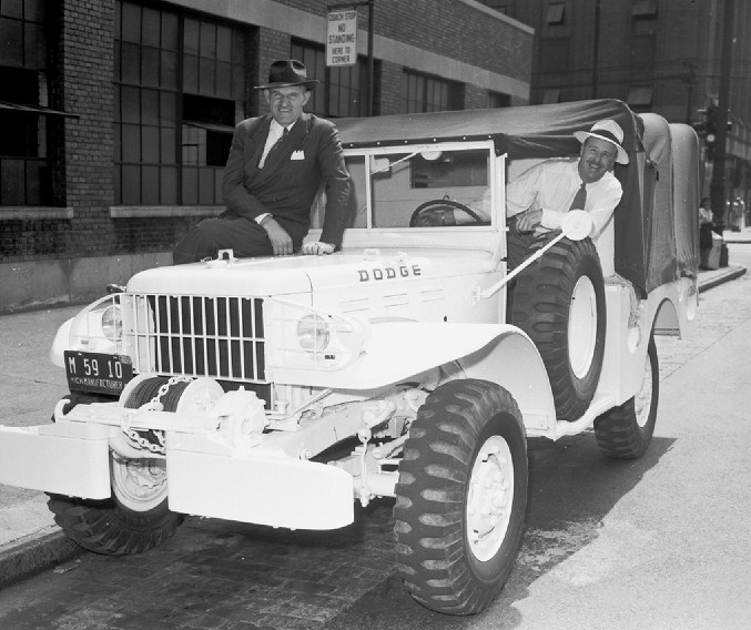 two men in suits and hats are standing next to an antique pickup truck