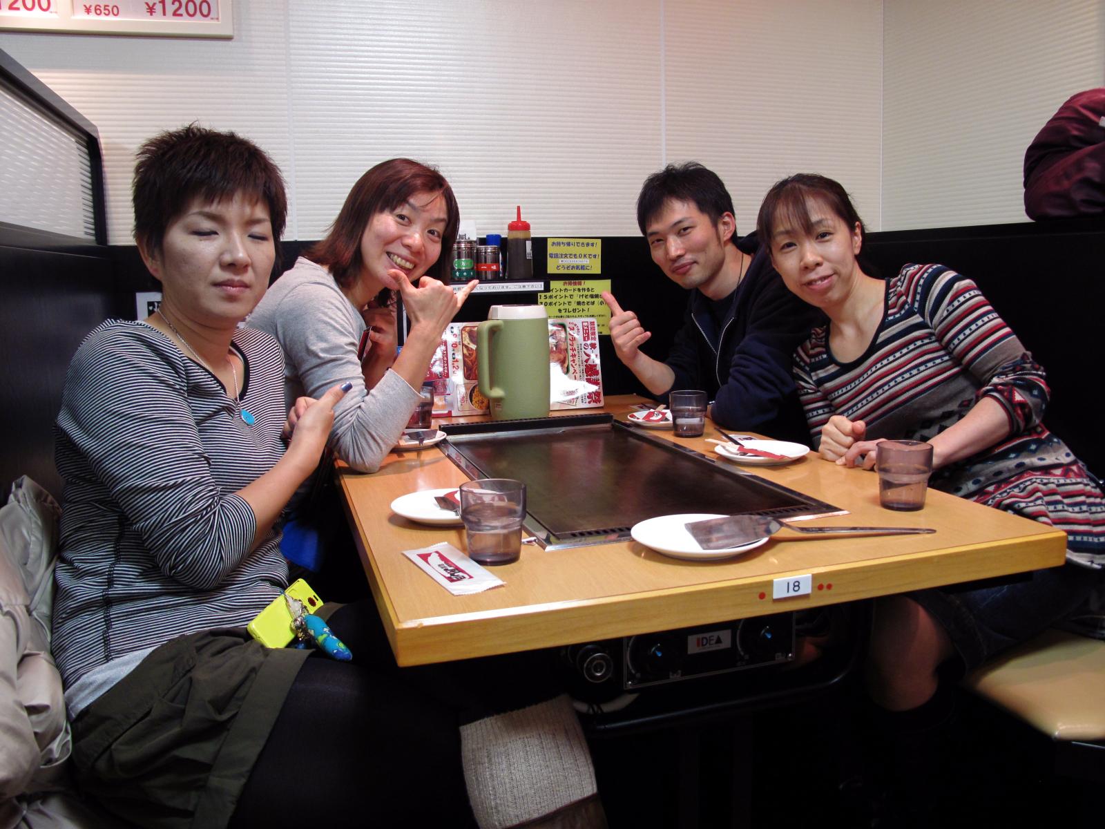 four young asian people enjoy meal at a diner