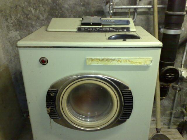 an old dirty laundry machine in a room