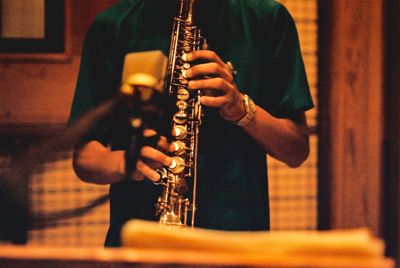 a man with glasses playing a saxophone in the room