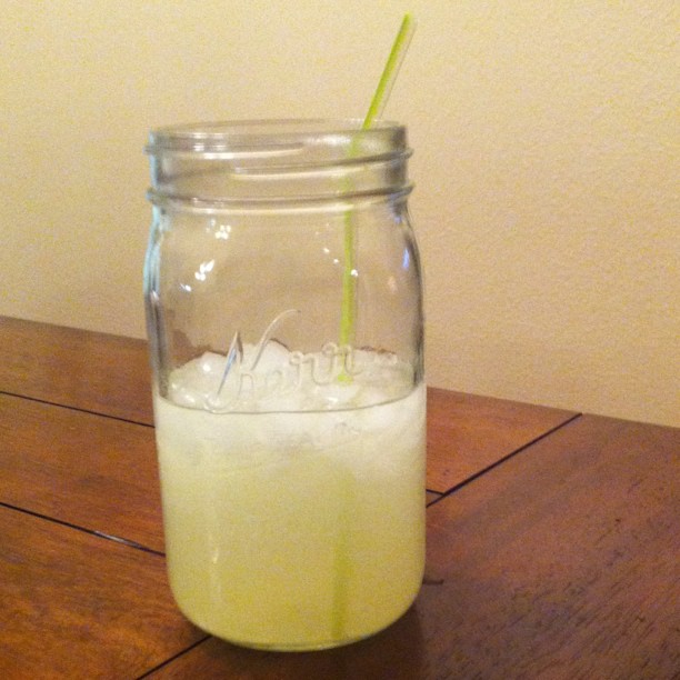 a full mason jar with a green straw