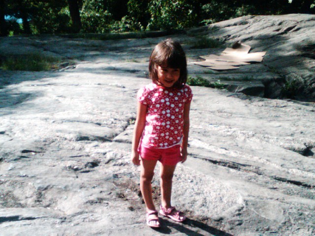 the small girl is walking on the rock path
