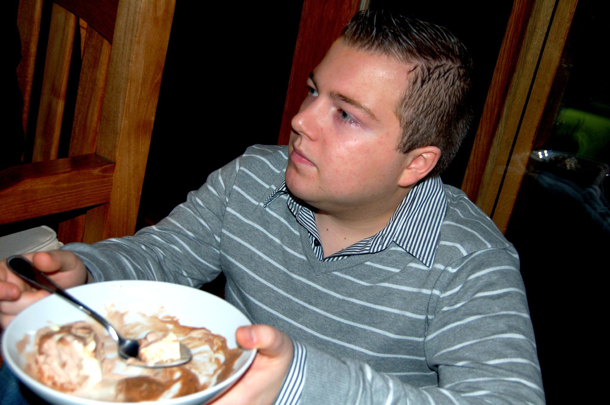 a person eating from a bowl with a spoon