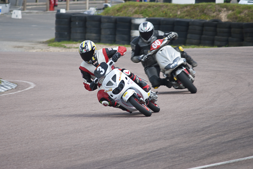 the motorcycle riders are racing on the race track