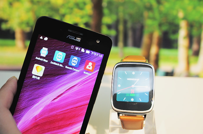 a smart watch sitting next to an lg phone