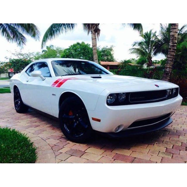 a dodge challenger on brick paved driveway